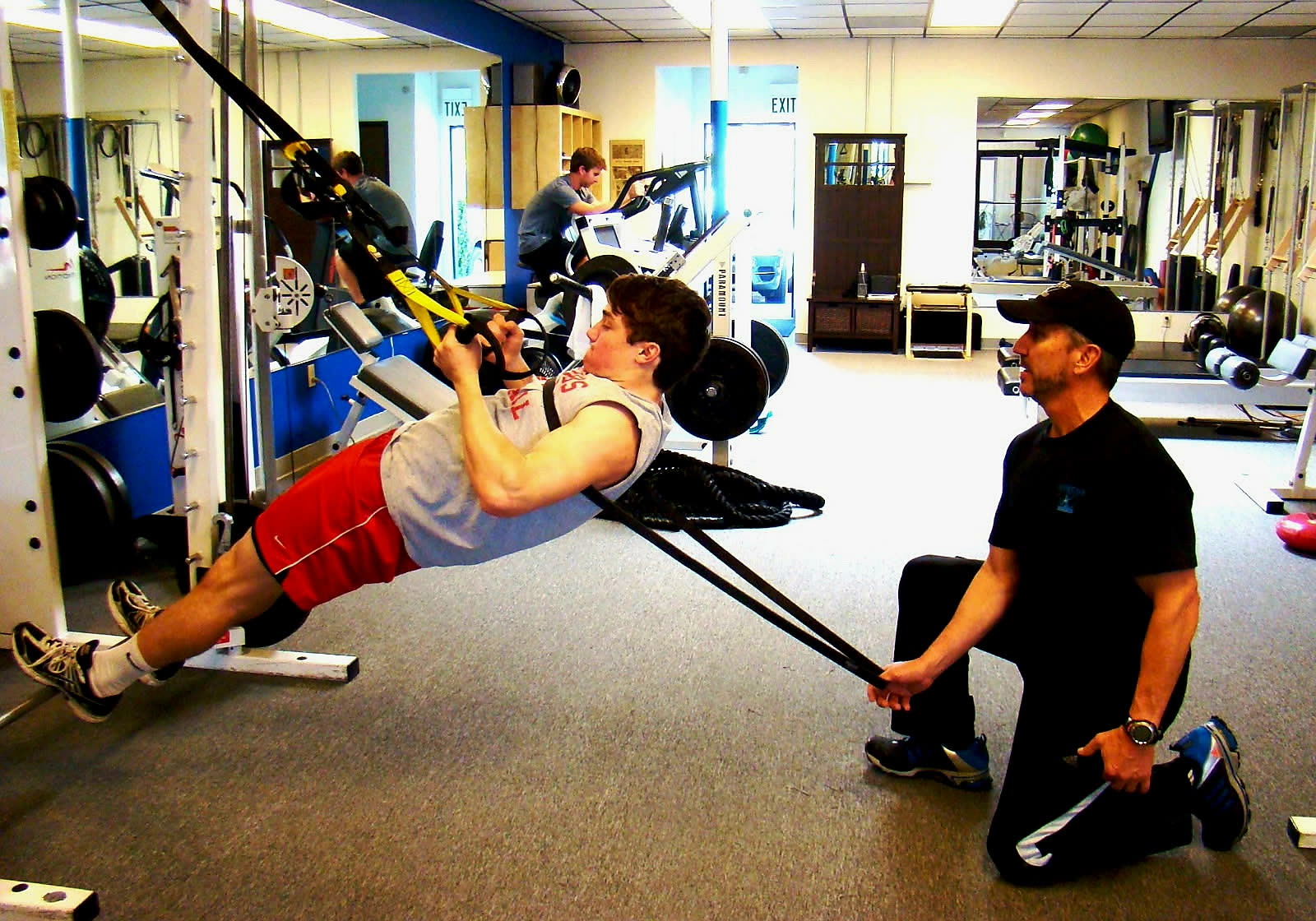 Norman McCallson coaching a client through TRX suspension rows at the Supreme Fitness studio